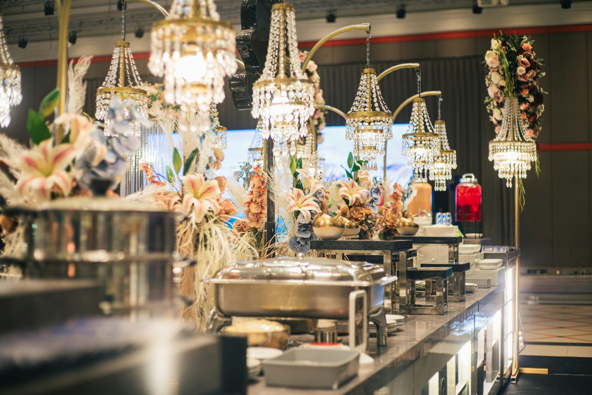 Luxurious buffet setting adorned with crystal chandeliers and floral decor for an opulent dining experience.